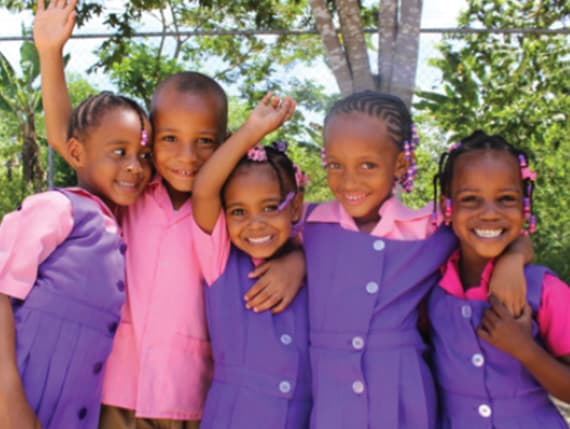 Children in pink and purple uniforms outside the Bunch of Stars Early Childhood Institution